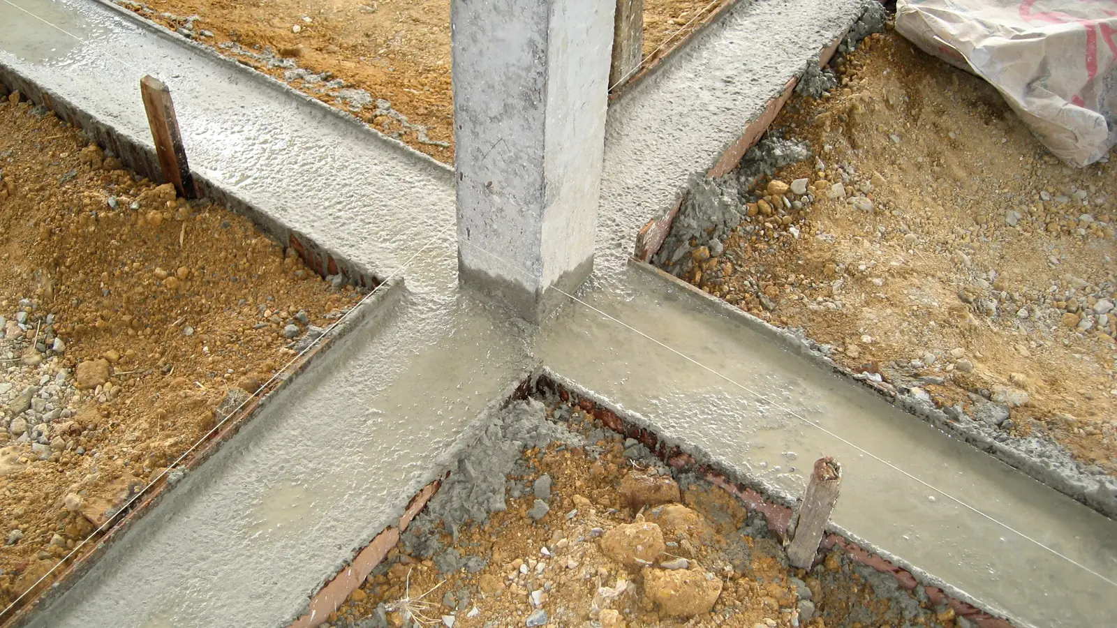 Betonpfosten in einem frisch gegossenen Streifenfundament