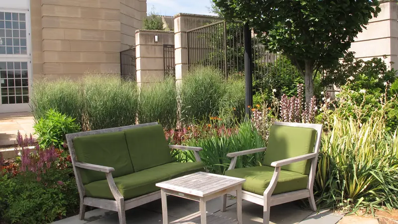 Sitzgruppe mit Sofa, Sessel und Tisch auf einer Gartenterrasse
